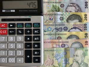 Un calculator împreună cu câteva bancnote românești